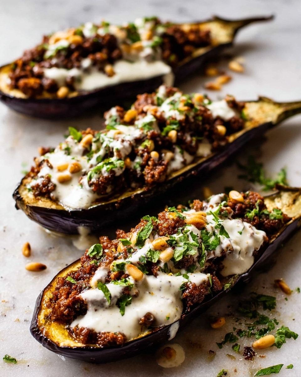 The image shows three roasted eggplant halves lined up diagonally on a white marbled surface. Each eggplant half has a dark purple, slightly wrinkled skin with a golden-brown cooked flesh. On top, there is a layer of cooked crumbled meat mixed with small bits of onion, dark brown in color with a slightly greasy texture. Over the meat, a thick white sauce is drizzled, flowing slightly over the sides. The dish is garnished with small green chopped herbs and scattered toasted pine nuts on top and around the eggplants. Photo taken with an iphone --ar 4:5 --v 7