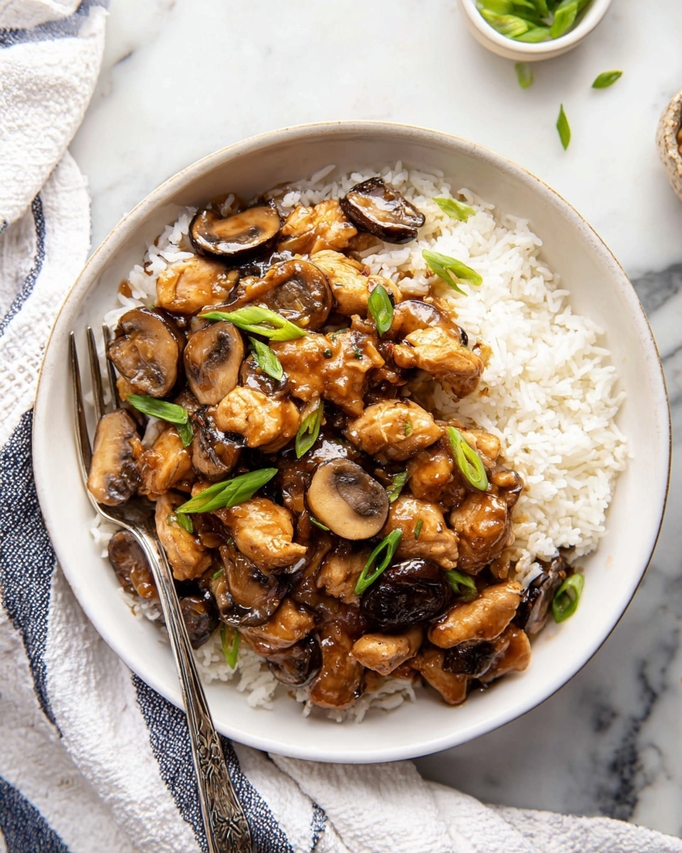 A white bowl filled with a base layer of white cooked rice, fluffy with separated grains. On top, a thick layer of cooked chicken pieces in a brown sauce mixed with sliced mushrooms that have a dark brown, slightly shiny texture. Green chopped scallions are scattered on the chicken and mushrooms, adding a fresh pop of color. A silver fork rests inside the bowl on the left side. The bowl sits on a white marbled surface with a white and blue striped cloth nearby. The photo is bright and clear, focused on the bowl. photo taken with an iphone --ar 4:5 --v 7