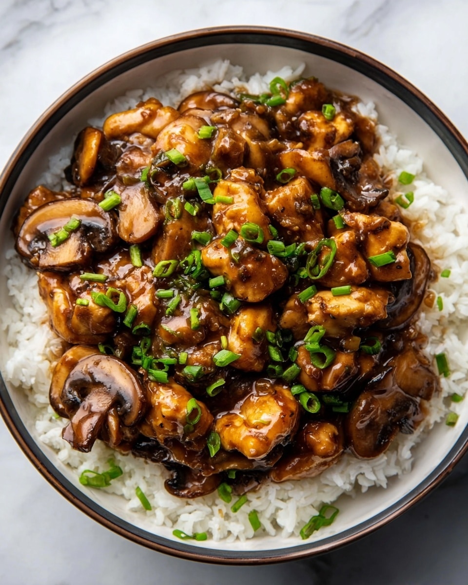 A deep white bowl filled with a layer of fluffy white rice at the bottom, topped with a generous layer of glossy brown chicken pieces and sliced mushrooms coated in a rich, thick sauce. The chicken and mushrooms are mixed closely, with bright green chopped scallions sprinkled on top, adding a fresh color contrast. The bowl sits on a white marbled surface in natural light, emphasizing the shiny texture of the sauce and the softness of the rice. photo taken with an iphone --ar 4:5 --v 7