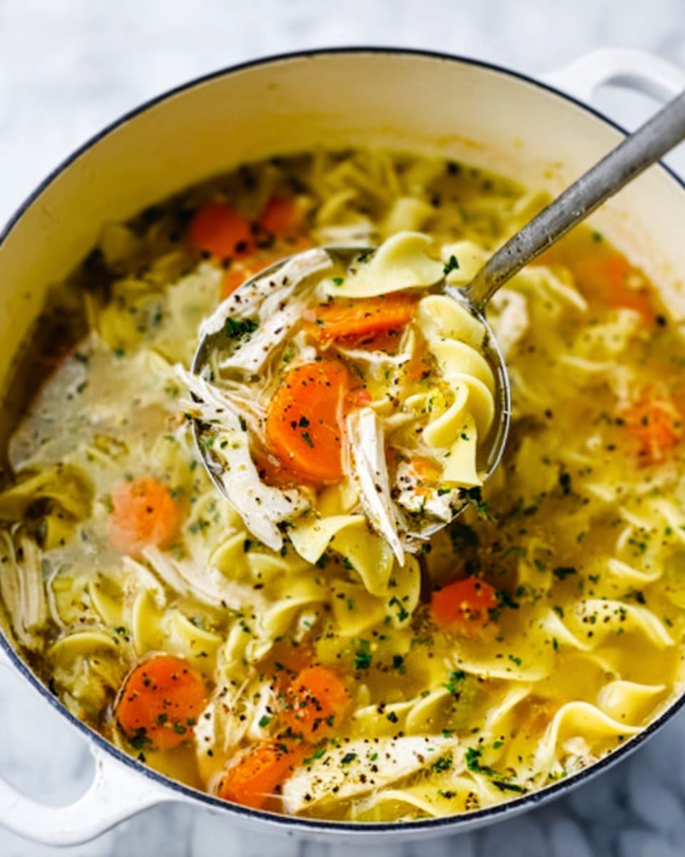 A white pot filled with clear chicken noodle soup with three layers: the bottom layer shows soft yellow egg noodles with wavy edges, the middle layer has bright orange carrot slices and shredded white chicken pieces, and the top layer is sprinkled with green herbs and black pepper. A ladle is partially lifting a scoop of soup showing all the layers inside the spoon. The pot sits on a white marbled surface. Photo taken with an iphone --ar 4:5 --v 7