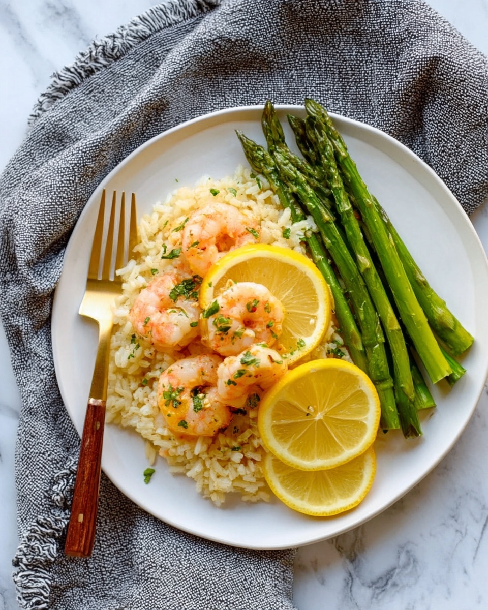 The image shows a white plate with three main layers: at the bottom, there is a layer of light beige rice with a soft texture; on top, there are two bright yellow lemon slices covered with small cooked pink shrimp scattered lightly, garnished with green herbs; on the right side of the plate, there are fresh green asparagus spears arranged neatly, with a half lemon placed beside them. A gold and wooden fork rests on the left side of the plate, and a gray textured cloth is visible in the background on a white marbled surface. Photo taken with an iphone --ar 4:5 --v 7