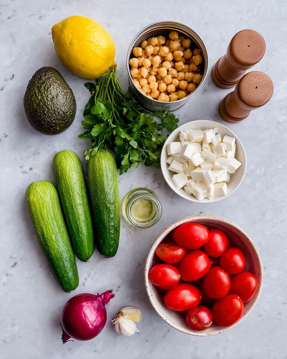 The image shows fresh ingredients arranged on a white marbled surface: a whole lemon on the top left, a dark green avocado below it, a bunch of green cilantro on the far left, and three long green cucumbers placed diagonally in the middle. Near the bottom center, there is a small red onion and a single garlic clove next to it. On the right side, a white bowl filled with bright red grape tomatoes sits above another white bowl filled with small white cheese cubes. Above the bowls, an opened tin can of chickpeas with golden chickpeas visible inside is placed. Between the lemon and the bowls, a small clear glass bottle with a cork and two wooden spice shakers stand side by side. photo taken with an iphone --ar 4:5 --v 7