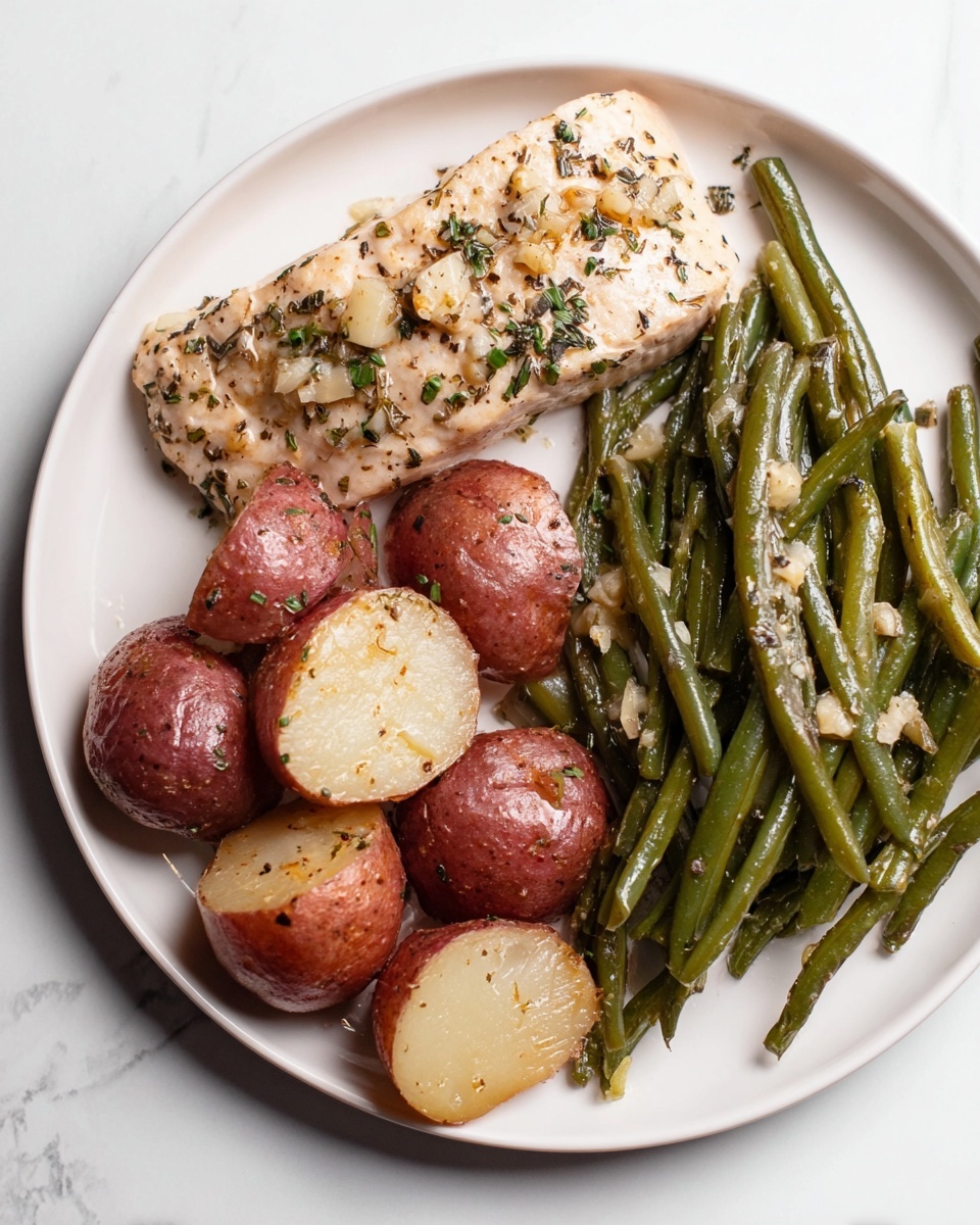 A white plate holds three main parts: on the top is a light beige piece of cooked fish sprinkled with small bits of herbs and garlic; below the fish are several halved red potatoes with a shiny skin and soft white inside, mixed with small pieces of herbs; to the right and slightly below the potatoes, there is a pile of glossy green beans, also seasoned with herbs and tiny garlic bits. The plate sits on a white marbled surface. Photo taken with an iphone --ar 4:5 --v 7