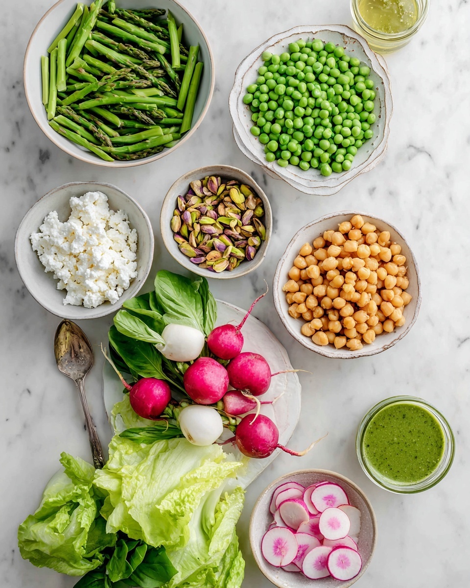 The image shows a collection of fresh and colorful ingredients arranged neatly on a white marbled surface. There are eight white bowls and plates, each holding different items: one bowl is full of bright green chopped asparagus at the top, another with vibrant green peas on the left, and a bowl of golden roasted chickpeas on the right. A small bowl at the bottom holds white crumbled cheese, while another small bowl contains light green and pink watermelon radish slices. Near the center, there are whole radishes with red skin and white insides and a bunch of fresh green basil leaves. Next to the chickpeas is a small bowl filled with roughly chopped pistachios, and a jar of green dressing with a spoon sits nearby. Crisp light green lettuce leaves are spread out near the center-bottom. photo taken with an iphone --ar 4:5 --v 7