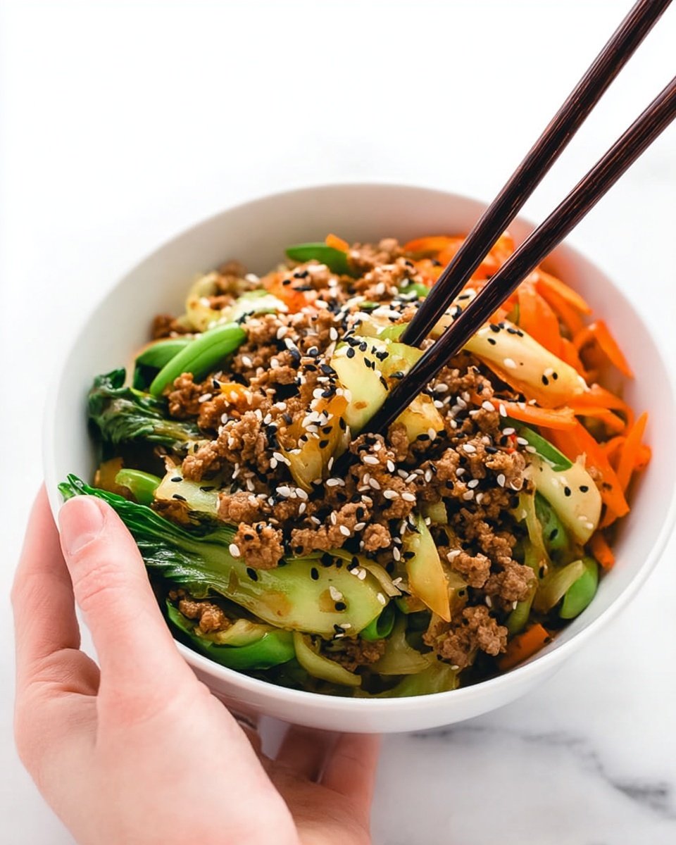 A white bowl filled with three layers: the bottom layer has small pieces of cooked ground meat in a light brown color, the middle layer consists of bright green cooked vegetables including bok choy and snap peas, and thin orange carrot strips, while the top layer is sprinkled with white and black sesame seeds adding texture and contrast. A woman's hand is holding dark brown chopsticks picking up some of the food from the bowl. The bowl sits on a white marbled surface. Photo taken with an iphone --ar 4:5 --v 7