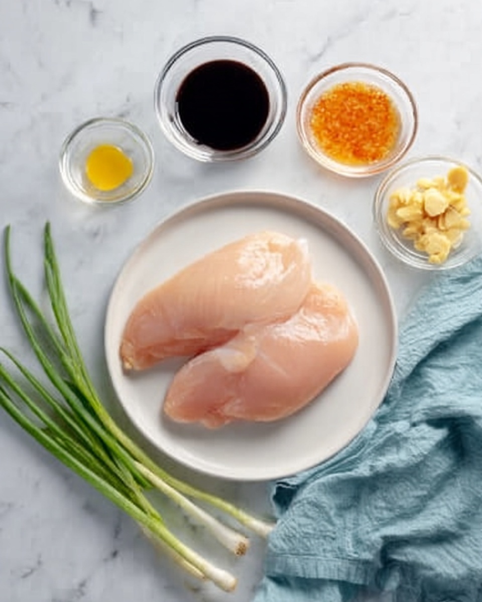 The image shows two raw chicken fillets placed side by side on a white plate, centered on a white marbled surface. Around the plate, there are five small clear glass bowls containing different ingredients: one bowl with dark soy sauce at the top right, one with orange chili sauce below it, one with a small yellow oil pool on the left, and one with chopped light yellow ginger pieces at the top right corner. A few whole green onions lay diagonally on the surface to the bottom right, and a light blue cloth is casually placed to the left side of the plate. The scene is bright, clean, and simple, focusing on the fresh ingredients photo taken with an iphone --ar 4:5 --v 7