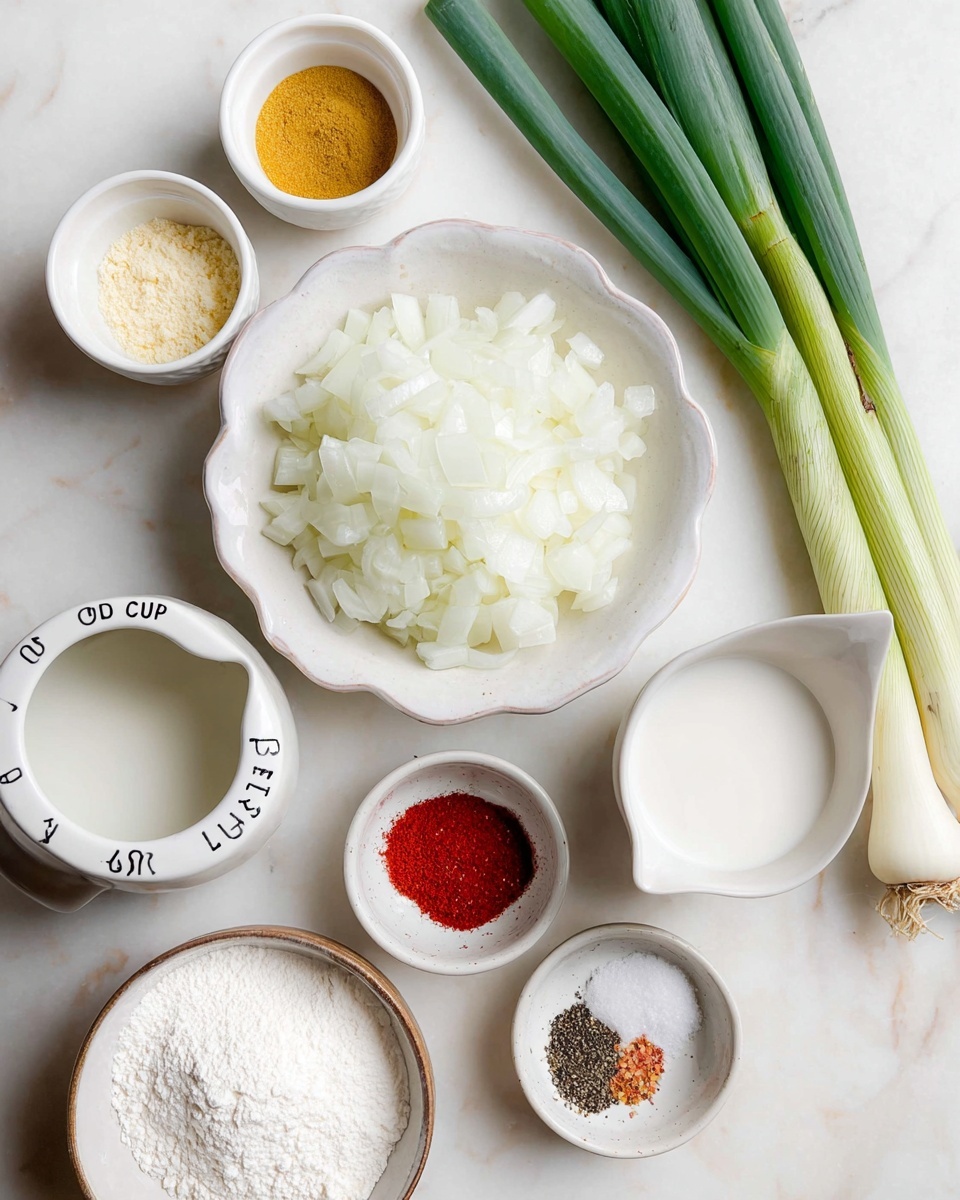 The image shows several small white bowls and cups arranged on a white marbled surface. In the center, a scalloped white bowl is filled with chopped white onions, which have a soft, translucent texture. Above to the right, three fresh green onions with long, smooth green stalks lay diagonally. To the left of the chopped onions is a small white bowl with a yellow powder, and next to it, a small white cup holds some white powder. Below is a ceramic white measuring cup labeled