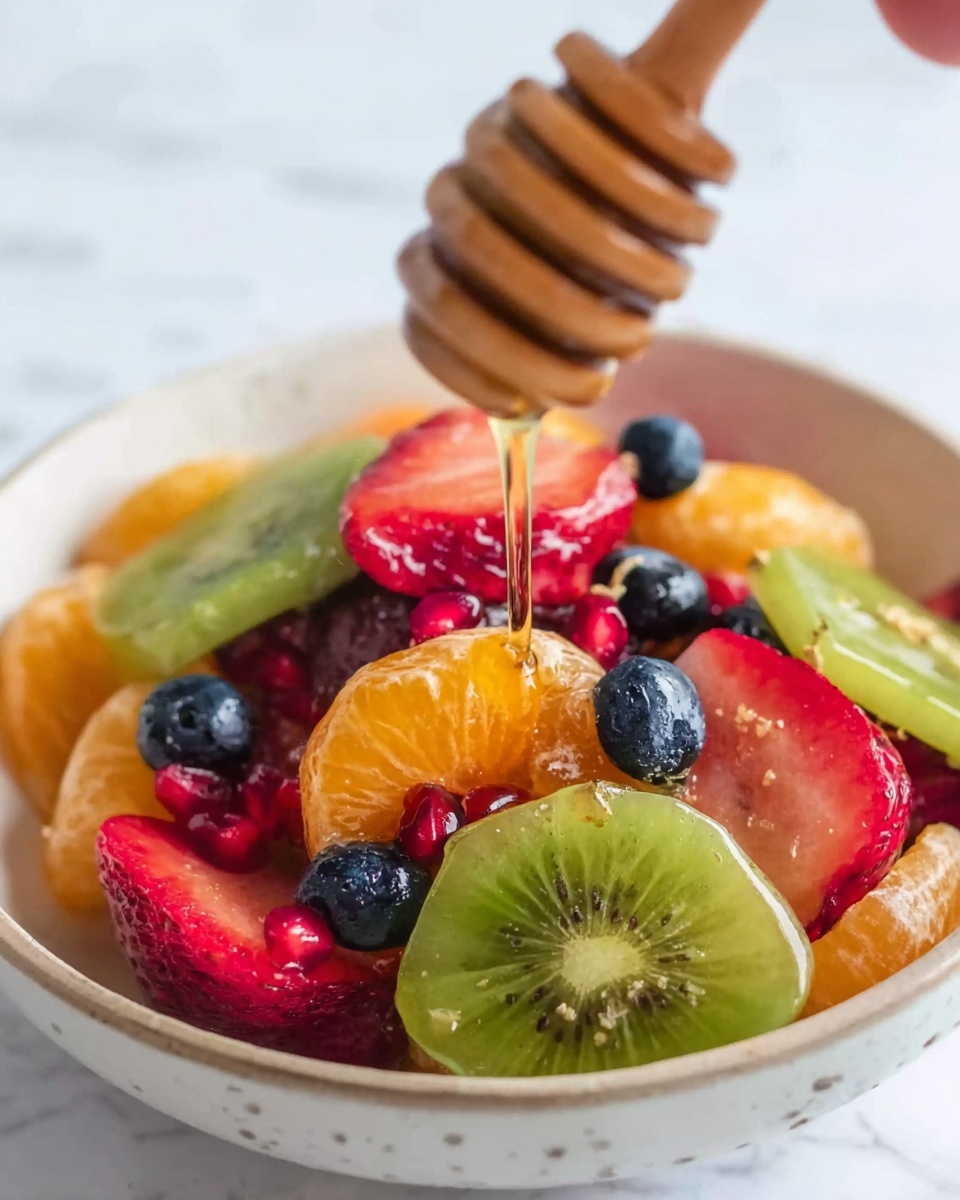 A white bowl filled with a colorful mix of fresh fruit slices sits on a white marbled surface. At the bottom, there are bright orange mandarin segments and green kiwi slices. On top of these, there are red strawberry slices, blueberries, and small red pomegranate seeds adding extra color and texture. A wooden honey dipper held by a woman's hand is dripping honey over the fruit, creating a shiny, smooth layer on the fruits below. The close-up view shows the juicy texture of the fruit and the glistening honey. photo taken with an iphone --ar 4:5 --v 7
