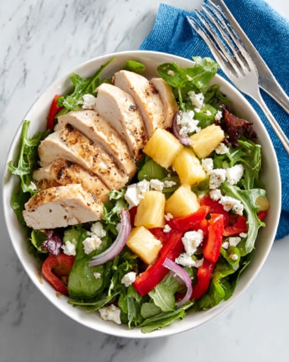 A white bowl filled with a fresh salad sits on a white marbled surface next to a blue napkin with a silver fork. The salad contains a bed of mixed leafy greens as the base layer, topped with thin slices of cooked chicken arranged in a fan shape on one side. Scattered over the greens are small cubes of yellow pineapple, thin slices of red bell pepper, and crumbled white cheese. The overall look is colorful and fresh. Photo taken with an iphone --ar 4:5 --v 7
