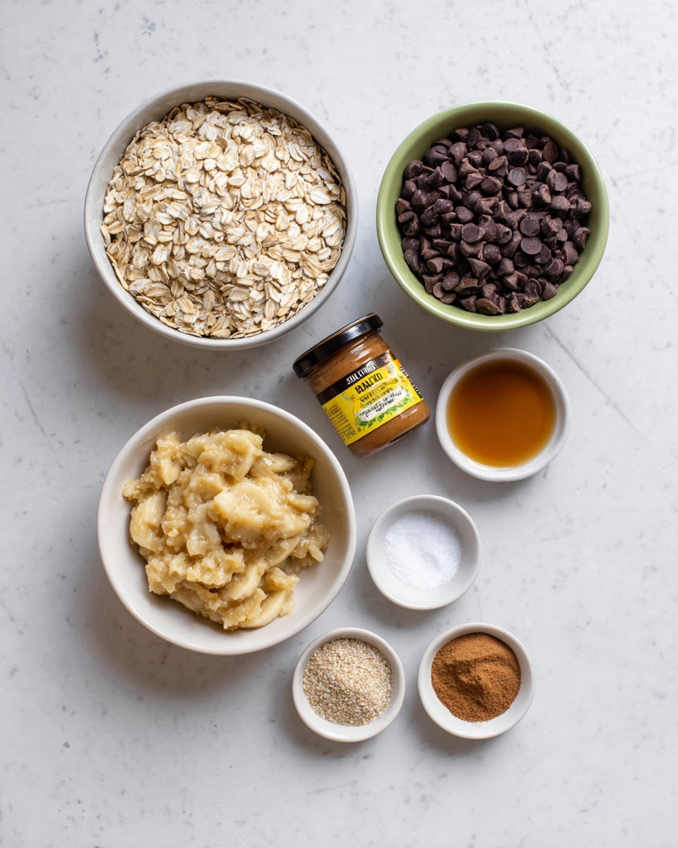 Banana Oatmeal Chocolate Chip Bars Recipe 4 The image shows six ingredients laid out on a white marbled surface: a jar of almond butter with a yellow and black label, a large white bowl filled with light tan rolled oats, a small white bowl full of dark brown chocolate chips, a white bowl containing mashed banana that looks soft and creamy with a slightly chunky texture, a small white bowl with a light brown liquid, and a small white bowl with ground spices including light brown cinnamon and white salt. Each item is clearly separated and arranged neatly in a way that makes each ingredient easy to see. Photo taken with an iphone --ar 4:5 --v 7