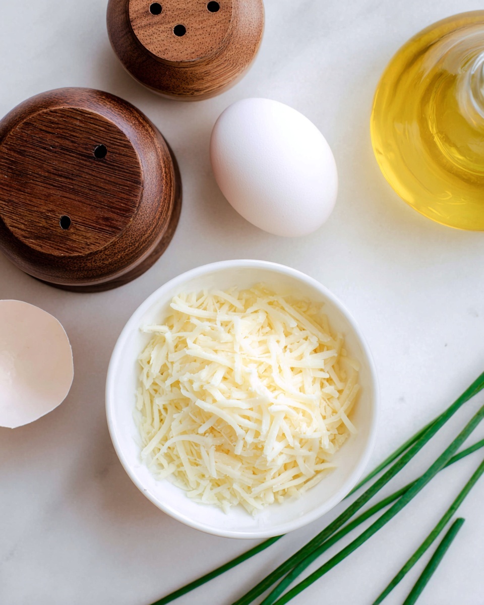A close-up image shows a white bowl filled with a layer of finely shredded pale yellow cheese. To the top left, there are two brown wooden containers, one larger with small holes on top and a smaller closed one beside it. Above the bowl, there is a white egg with a smooth shell and next to it, part of a round glass bottle filled with yellow liquid, likely oil. Two long, thin green chives lie diagonally on the bottom right on a white marbled surface photo taken with an iphone --ar 4:5 --v 7