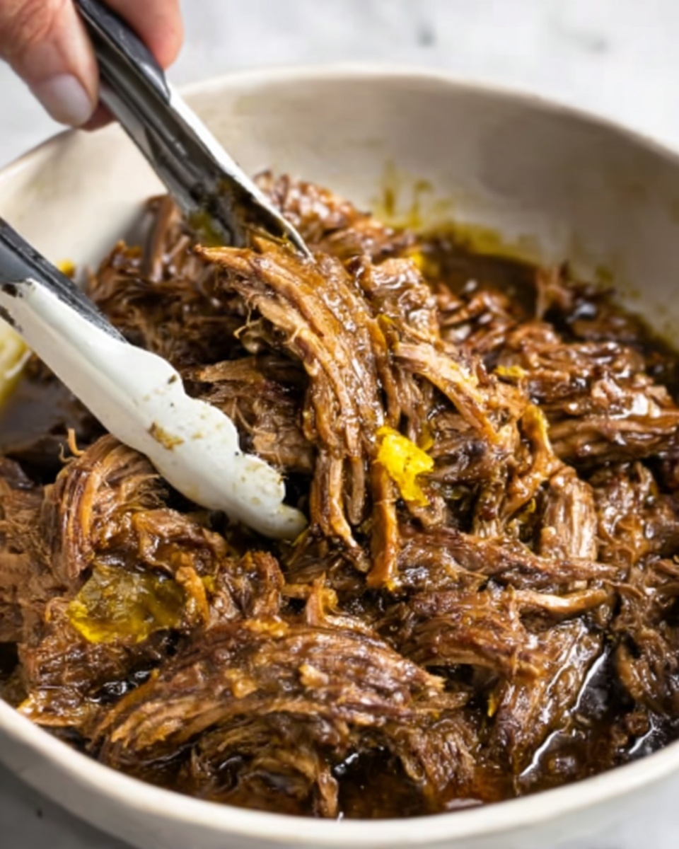 The image shows a close-up of shredded, cooked meat with a dark brown color, mixed with a few small yellow pieces, all in a white bowl. A pair of white tongs is lifting some of the meat, and a woman's hand is holding the tongs. The meat looks tender and juicy with a glossy texture, sitting in a dark sauce that covers the bottom of the bowl. The background is a white marbled surface. photo taken with an iphone --ar 4:5 --v 7
