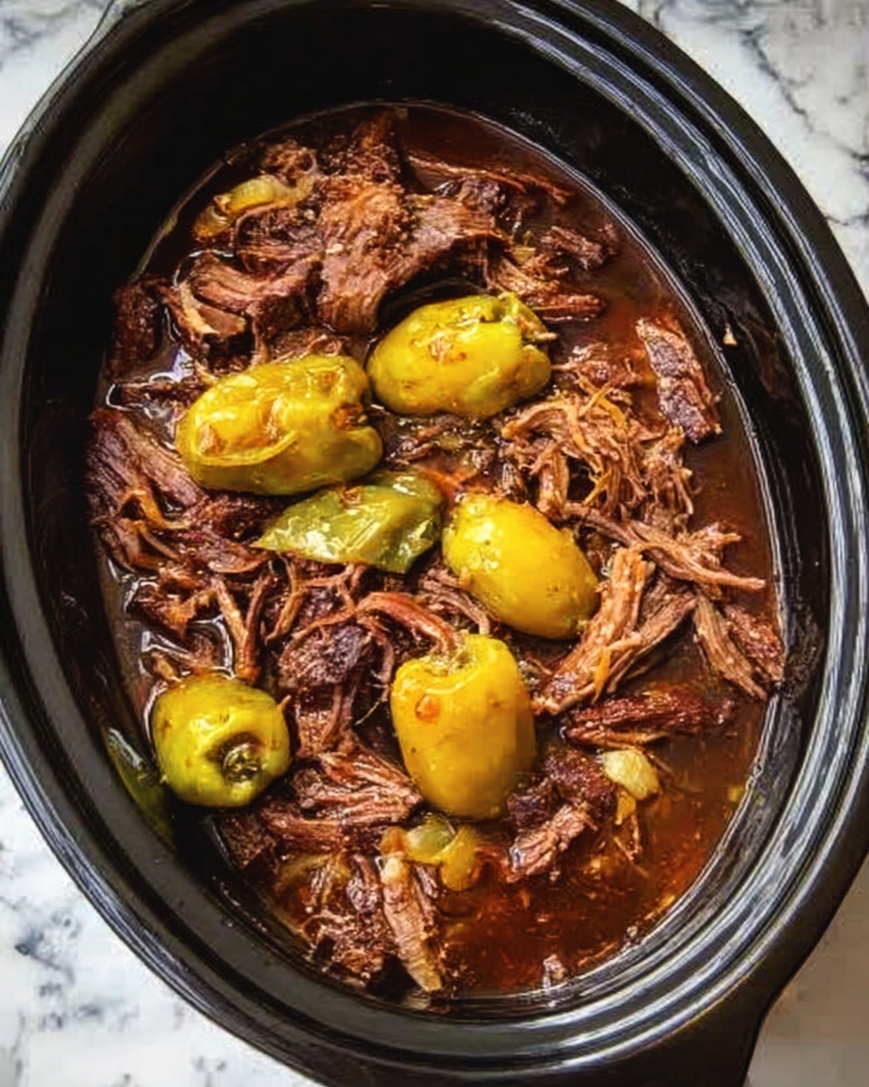 Mississippi Pot Roast with Creamy Jalapeño Cheddar Grits Recipe 5 A black oval slow cooker filled with rich brown shredded meat soaked in a dark brown sauce, with several whole yellowish-green peppers placed on top and mixed within the meat layers, all resting on a white marbled surface. photo taken with an iphone --ar 4:5 --v 7