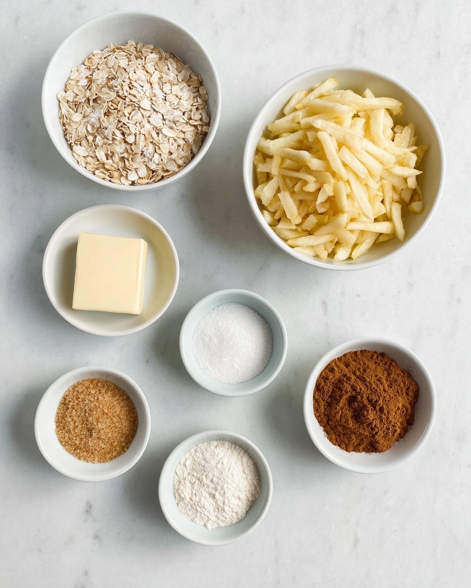 The image shows eight white round bowls arranged on a white marbled surface. The largest bowl at the top right is filled with thin, light yellow strips of chopped apple. To the left of it, a medium white bowl holds light beige rolled oats. Below, a smaller bowl contains a pale yellow stick of butter. Surrounding these are smaller bowls containing white granulated sugar, light brown packed brown sugar, fine white flour, a small mound of white powder (likely baking powder), and a bowl with ground cinnamon, a warm brown powder. All items are neatly placed, and the colors range from white and off-white to browns and yellows, contrasting gently against the white marbled background. Photo taken with an iphone --ar 4:5 --v 7