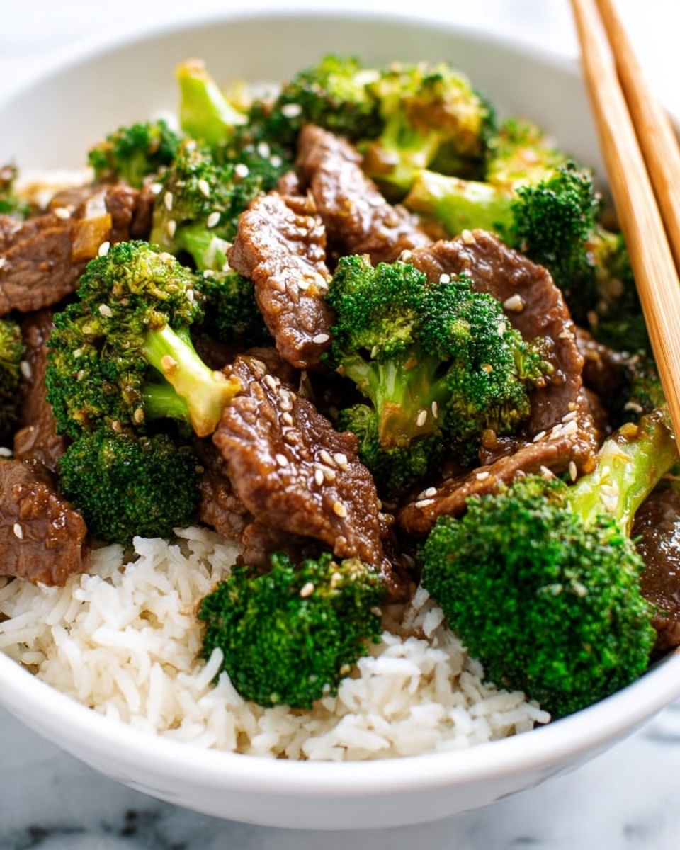 A close-up of a dish with dark brown beef slices and bright green broccoli florets in a glossy dark sauce, all inside a black pan. A wooden spoon holds a portion of the beef and broccoli, showing the textures of tender meat and fresh broccoli with small water droplets. The layers are the dark sauce base, topped by scattered beef slices and vibrant broccoli pieces evenly mixed throughout. The image is set on a white marbled texture. photo taken with an iphone --ar 4:5 --v 7