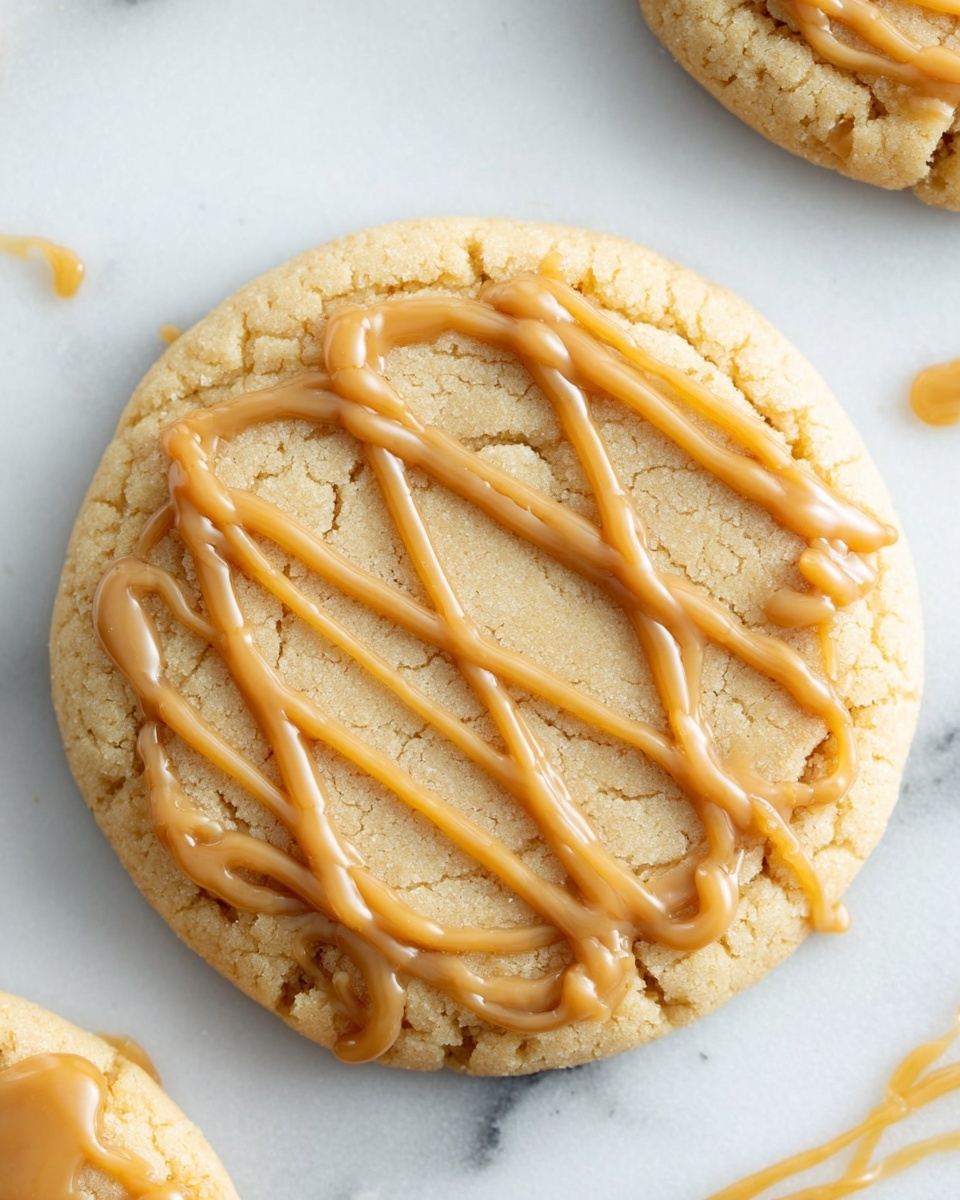 A close-up image of a peanut butter cookie with three visible layers: a soft, light brown cracked cookie base showing a rough texture, a thick creamy peanut butter filling in the center with a smooth, shiny surface, and a drizzled layer of slightly darker peanut butter on top forming a criss-cross pattern. The cookie is on a white marbled surface, with parts of other similar cookies faintly visible in the background. One cookie is partially broken, revealing the creamy inside clearly. Photo taken with an iphone --ar 4:5 --v 7