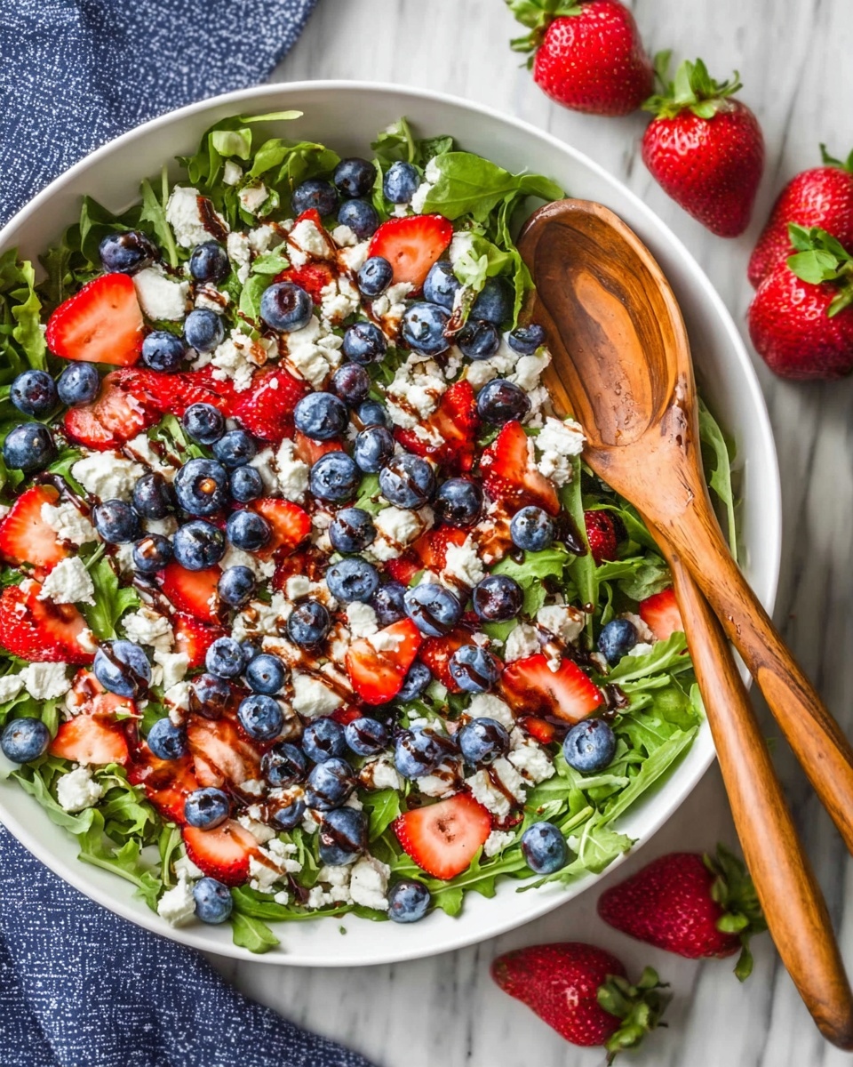 A big white bowl filled with a colorful salad sits on a white marbled surface. The salad has a base of green leafy arugula, with bright red sliced strawberries and round blue blueberries spread evenly on top. White crumbly pieces of cheese are scattered throughout the salad, and there are some dark brown drizzles of balsamic vinegar or dressing on the cheese. A wooden spoon rests inside the bowl, leaning diagonally from the right side. Around the bowl, there are fresh whole strawberries and blueberries on the white marbled surface. photo taken with an iphone --ar 4:5 --v 7