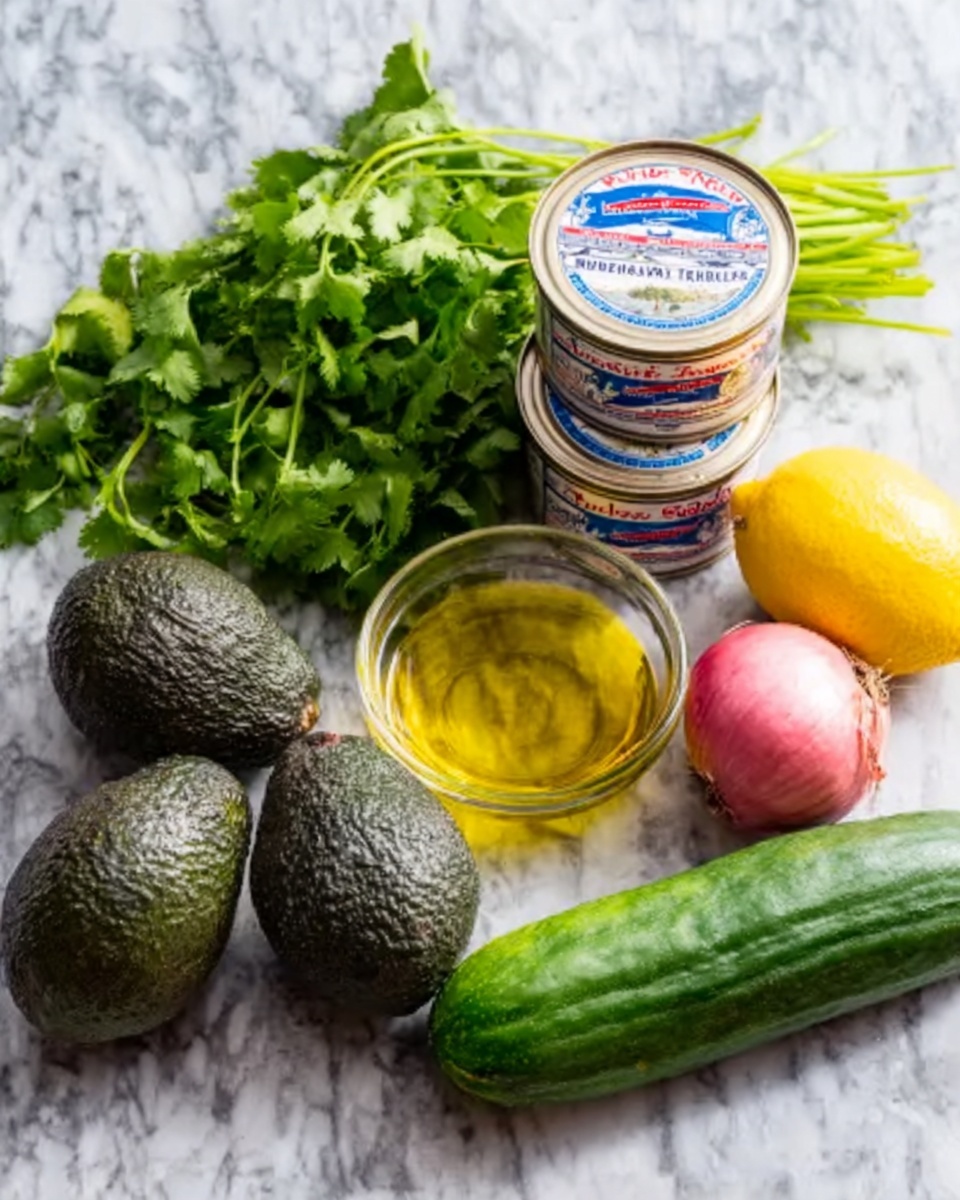 The image shows fresh ingredients arranged neatly on a white marbled surface. There are three dark green, pebbly textured avocados placed close to a bunch of bright green cilantro with leafy stems. Next to the avocados are three stacked cans of tuna with white and blue labels. To the right of the cans is a bright yellow lemon and a round, pinkish-red shallot with smooth skin. At the front, there is a long, dark green cucumber with a slightly bumpy texture. A small clear glass bowl filled with golden olive oil is set behind the tuna cans. photo taken with an iphone --ar 4:5 --v 7