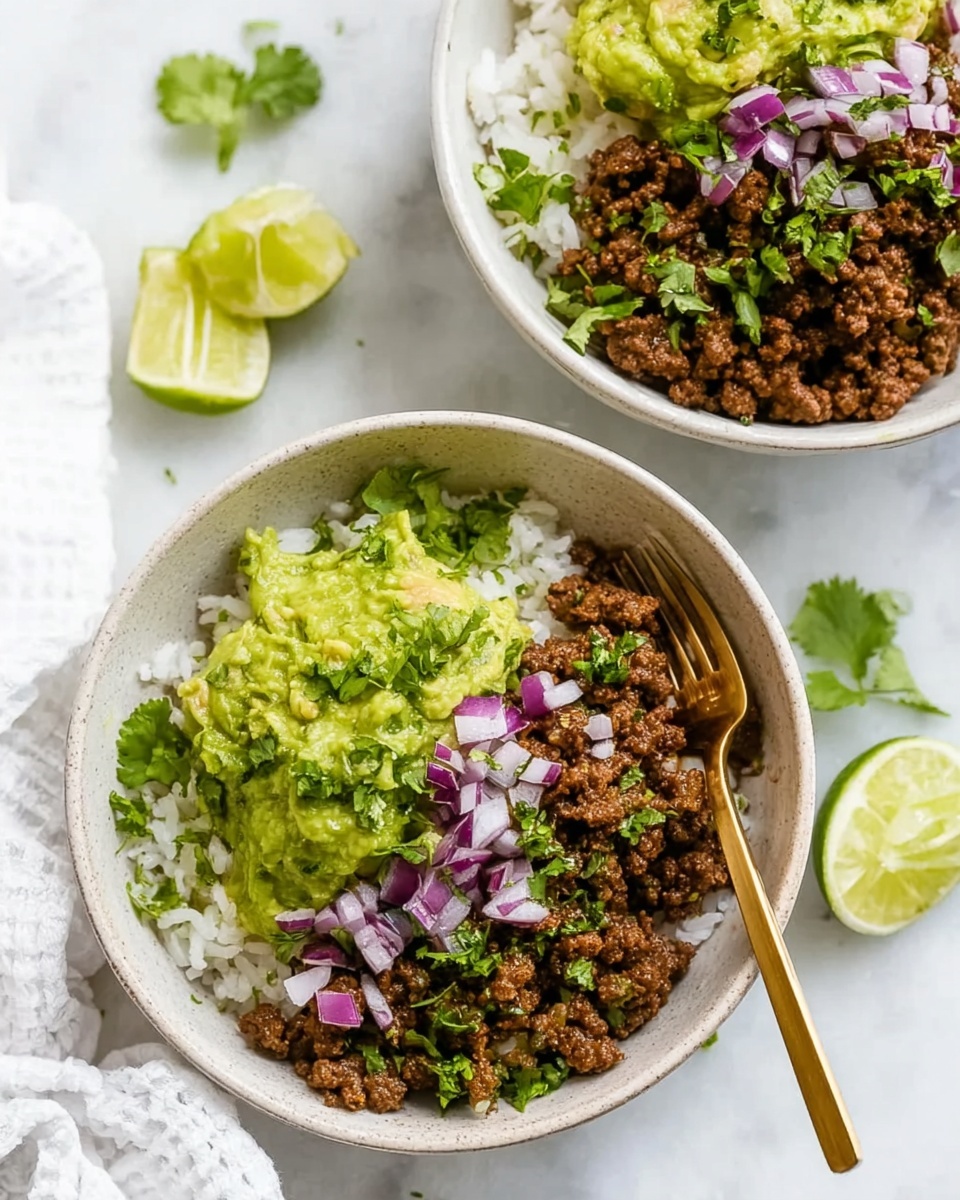 Two white bowls are filled with three main layers each: the bottom layer is white rice, the middle layer is brown spiced ground meat, and the top layer is green guacamole. The meat is garnished with small pieces of chopped white onion and purple-red onion, along with sprigs of fresh green cilantro scattered across the bowls. One bowl has a gold fork resting on the edge. The bowls are placed on a white marbled surface with lime wedges and a white cloth nearby. Photo taken with an iphone --ar 4:5 --v 7