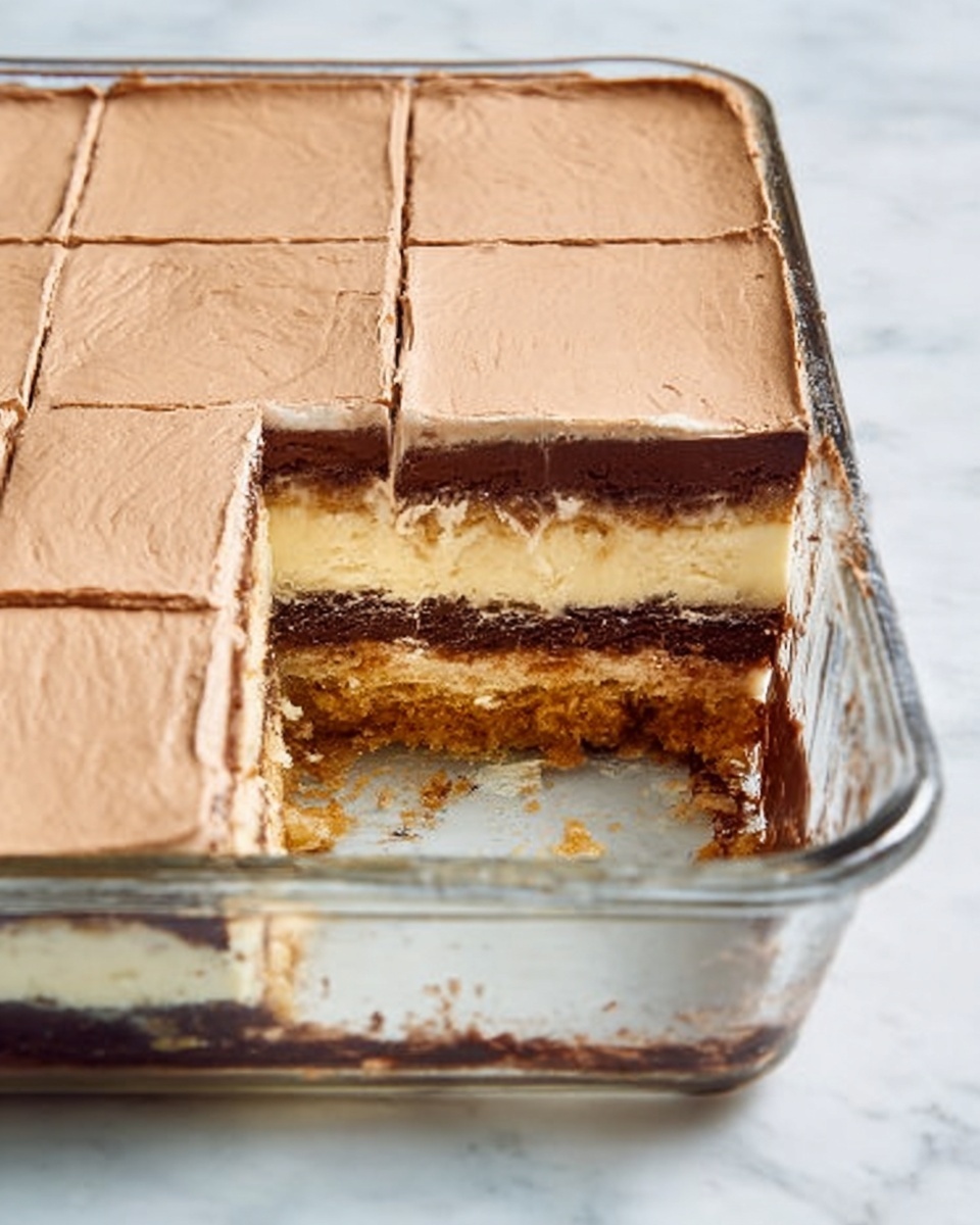 A clear glass rectangular dish holds a layered dessert with six visible layers. The top layer is a smooth, light tan frosting spread evenly, with square cuts marking each piece. Below it is a thick, creamy light brown layer, followed by a darker, rich chocolate layer making a sharp contrast. Under the chocolate is a crumbly tan layer resembling a cookie crust, sitting above a thin pale layer that looks like a base or batter. The bottom layer is a mix of crumb and dense cake in light and dark brown tones. A piece is missing from the dish, showing all layers clearly. The dish rests on a white marbled surface. Photo taken with an iphone --ar 4:5 --v 7
