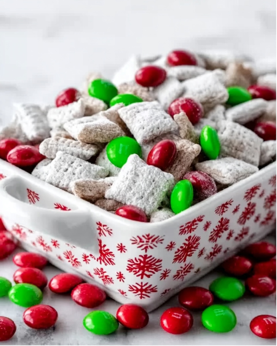 A white, rectangular dish with red and white snowflake patterns is filled to the top with a chewy snack mix of square cereal pieces dusted in white powder. Scattered around the dish are more of these cereal pieces mixed with shiny red and green round candies. The colors are bright and festive, perfect for a holiday theme, all set on a white marbled surface. photo taken with an iphone --ar 4:5 --v 7