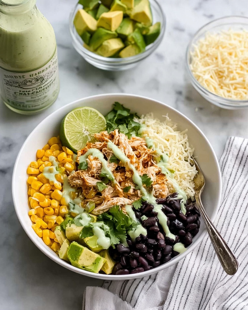 A white bowl sits on a white marbled surface, filled with four distinct layers arranged in sections: bright yellow corn kernels on the bottom left, soft shredded chicken mixed with small bits of corn and a light green sauce drizzled over it on the top left, a pile of shiny black beans on the top right, and light green avocado chunks paired with a serving of white shredded cheese on the bottom right. A lime wedge rests on the left edge of the bowl with fresh green cilantro sprinkled over the chicken and cheese. A silver fork is placed on the right edge of the bowl, partially resting on the avocado and cheese. In the background, a clear glass bowl with avocado chunks and lime, a white bowl of corn, and a bottle of light green sauce are visible on a white marbled surface with a striped cloth underneath. Photo taken with an iphone --ar 4:5 --v 7