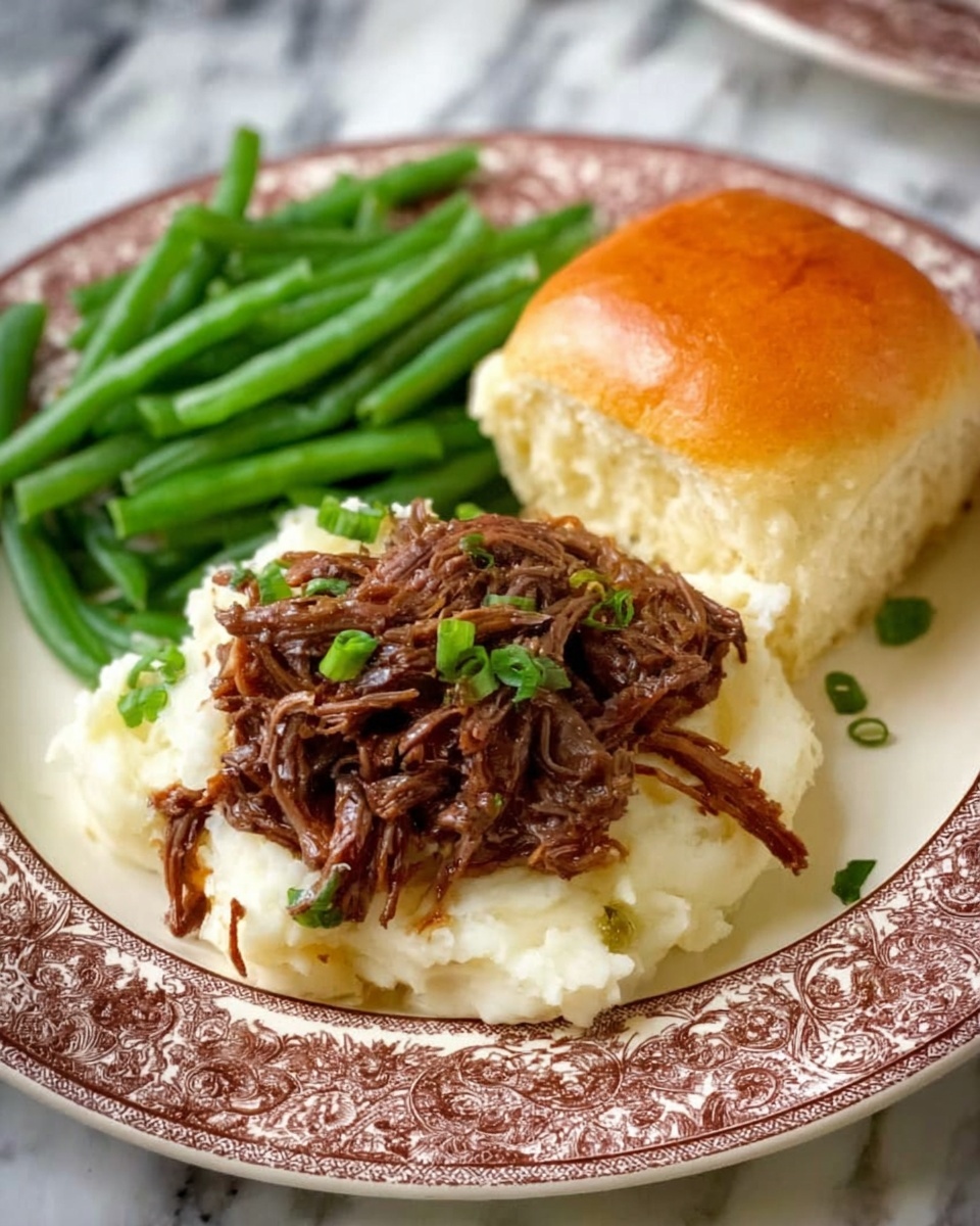 A white plate with a brown patterned rim holds three sections: on the left, a neat pile of bright green beans with a slightly shiny texture; in the center, a bed of creamy white mashed potatoes topped with shredded dark brown meat garnished with small pieces of green onion; on the right, a soft, golden brown dinner roll with a smooth surface. The background shows a white marbled texture. Photo taken with an iphone --ar 4:5 --v 7