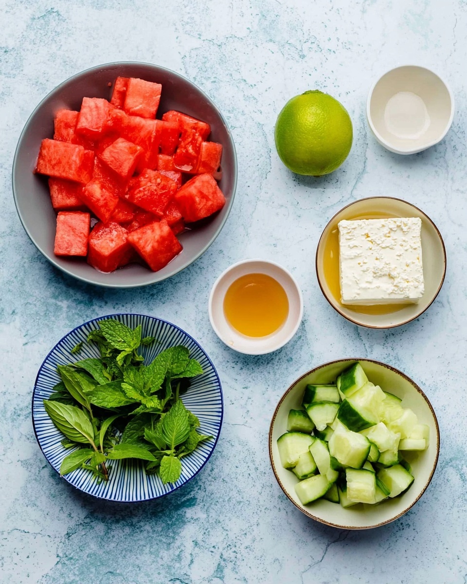 The image shows six bowls on a white marbled surface. In the top left corner, a grey bowl is full of bright red watermelon cubes. To its right, from left to right, there is a half lime with light green inside, a small white bowl with golden honey, and an empty small white bowl. On the bottom left, a white bowl with a blue rim has fresh green herbs, including basil and mint leaves. Next to it, in the center bottom, a white bowl with a blue rim holds a square piece of white feta cheese. On the bottom right, another grey bowl contains green cucumber chunks with their darker skin showing. The photo taken with an iphone --ar 4:5 --v 7
