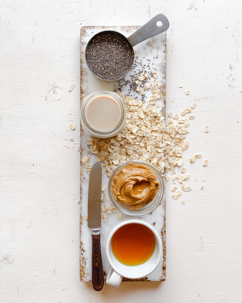 A top view of a white marbled textured board with five main items arranged vertically: at the top, a metal scoop holds small, dark brown chia seeds; below it, a round metal measuring cup filled with light tan rolled oats, some oats scattered around; next, a clear glass jar with a light beige liquid, likely almond milk; beneath that, a knife with a dark wooden handle holding a thick dollop of creamy light brown peanut butter; and at the bottom, a small white ceramic cup filled with amber-colored liquid, possibly honey or syrup, with some rolled oats around it. photo taken with an iphone --ar 4:5 --v 7