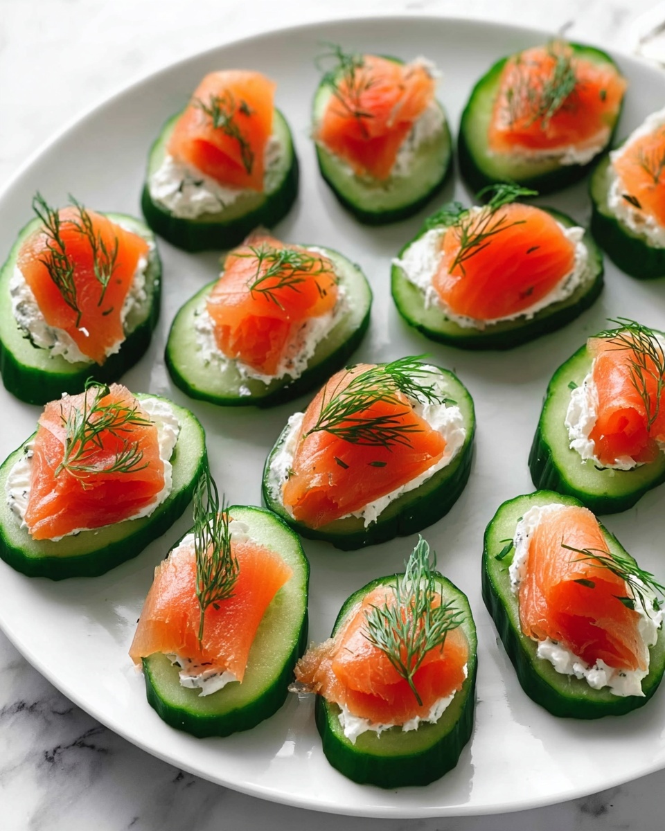 Thin oval slices of bright green cucumber are arranged neatly on a white plate set on a white marbled surface. Each cucumber slice holds a dollop of creamy white spread, topped with a smooth layer of orange smoked salmon that has a slightly shiny texture. On top of each salmon piece is a small sprig of fresh green dill, adding a fine feathery detail. The pieces are spaced evenly, filling the plate mostly but leaving some white space around the edges. Photo taken with an iphone --ar 4:5 --v 7