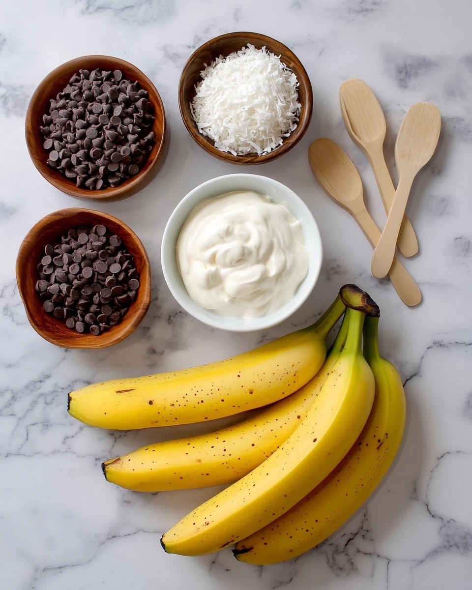 The image shows four ingredients arranged on a white marbled surface: at the bottom, three yellow bananas with small brown spots are grouped; above them, in the center, is a white bowl filled with dark chocolate chips; to the left of the bowl is a wooden bowl filled with white shredded coconut; to the right of the chocolate chips is a small pile of light wooden scoop-shaped spoons; at the top center, a wooden bowl contains thick creamy white yogurt. photo taken with an iphone --ar 4:5 --v 7