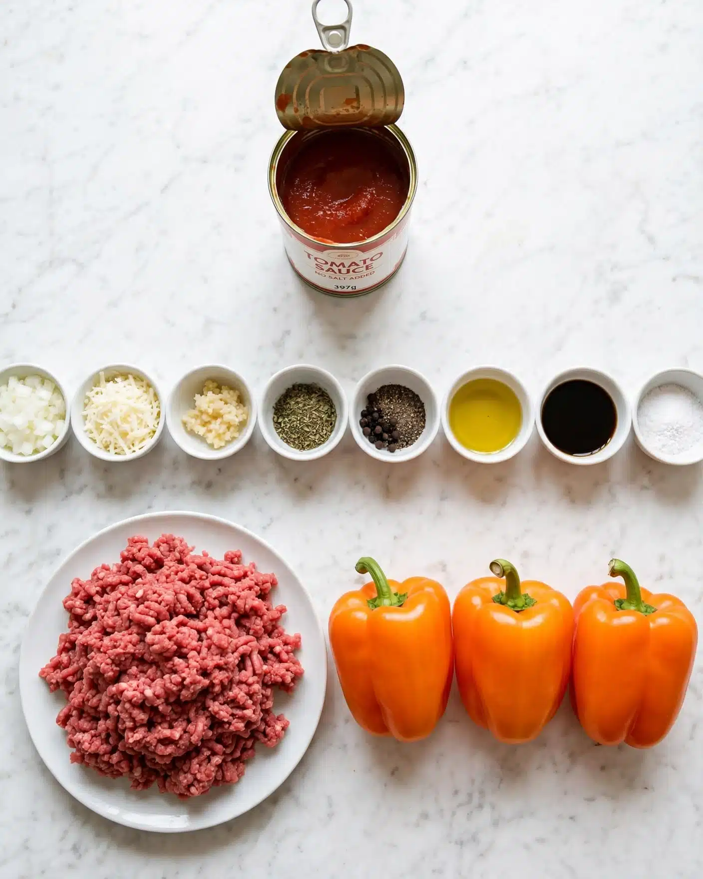 Stuffed Peppers with Ground Beef, Rice, and Melted Monterey Jack Cheese Recipe 4 The image shows many ingredients neatly arranged on a white marbled surface. There is a white plate with a big pile of red ground meat at the bottom left. Next to it on the right, there are three whole bright orange bell peppers placed close together. Above the meat, there are several small white bowls, each holding different ingredients: finely chopped white onion, shredded white cheese, minced garlic paste, dry herbs, black pepper, vegetable oil, soy sauce, and salt. At the top center, there is an open can of red tomato sauce. All items are spread out with space between them, creating an organized and clean look. Photo taken with an iphone --ar 4:5 --v 7