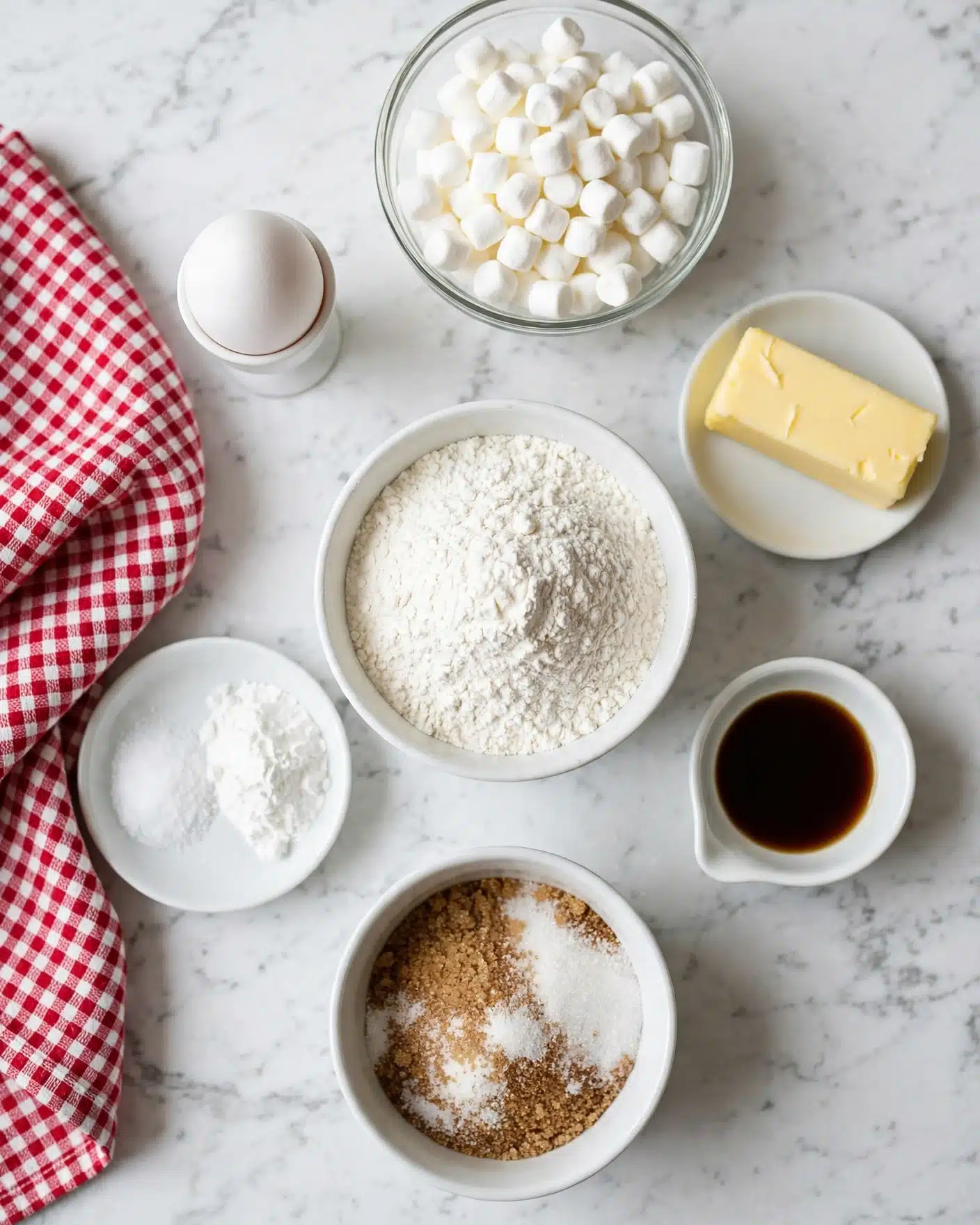 The image shows baking ingredients arranged on a white marbled surface, starting with a white bowl filled with white flour in the middle. Around it, there is a white bowl of brown and white sugar mixed together at the bottom, a white small dish with salt and baking powder on the left, a white small sauce dish with dark vanilla liquid on the right, a white dish holding a stick of yellow butter on the upper right, a clear glass bowl filled with white mini marshmallows on the top, and a white egg cup with a white egg standing on the upper left. A red and white checkered cloth is placed beside these items on the left. Photo taken with an iphone --ar 4:5 --v 7